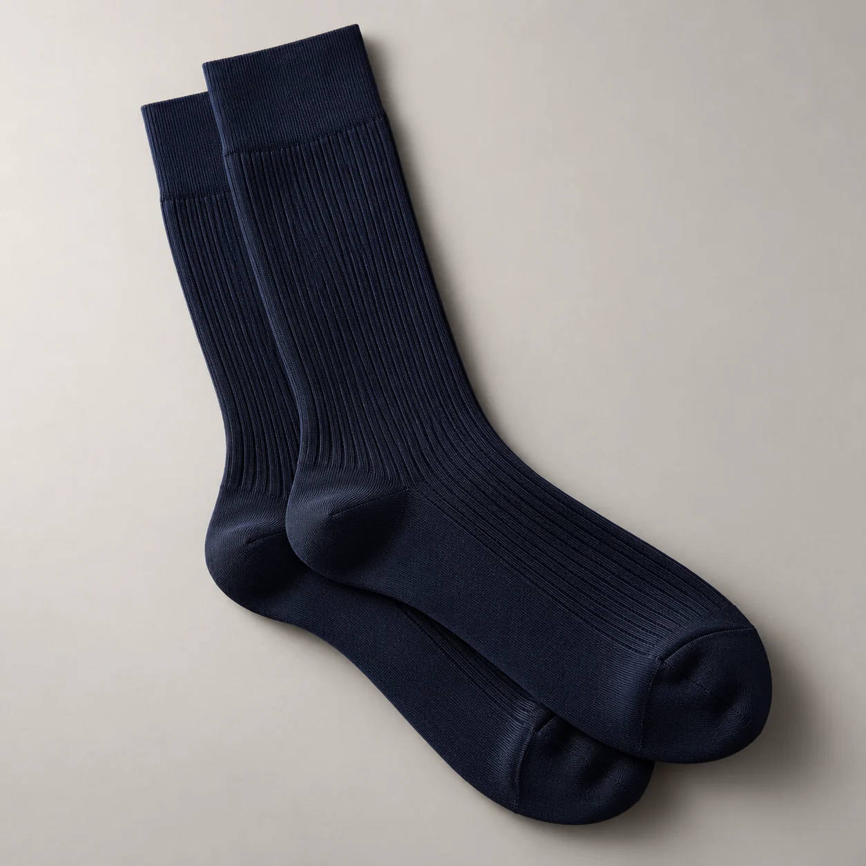 Navy fine-knit dress sock concept against a neutral background